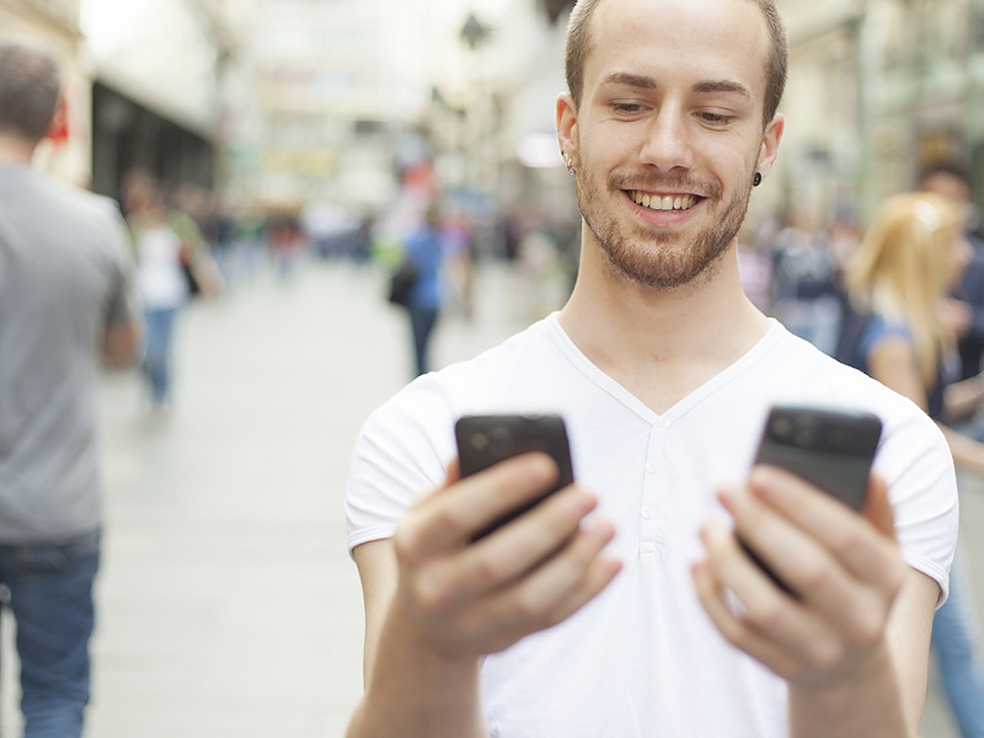 иметь 2 смартфона. 2 телефона в руках. молодежь с гаджетами. парень с телефоном. иметь 2 смартфона.
